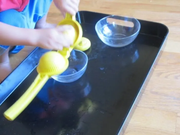 A child squeezing a lemon