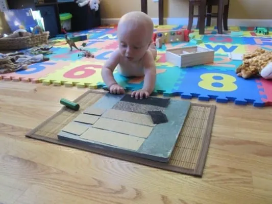 A child exploring a DIY texture board