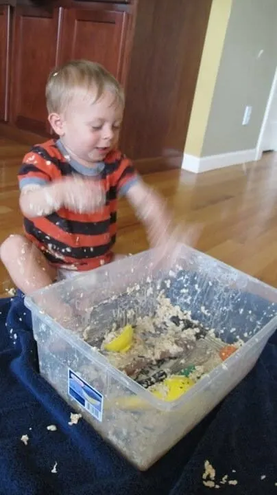 Boy playing in a messy sensory tub