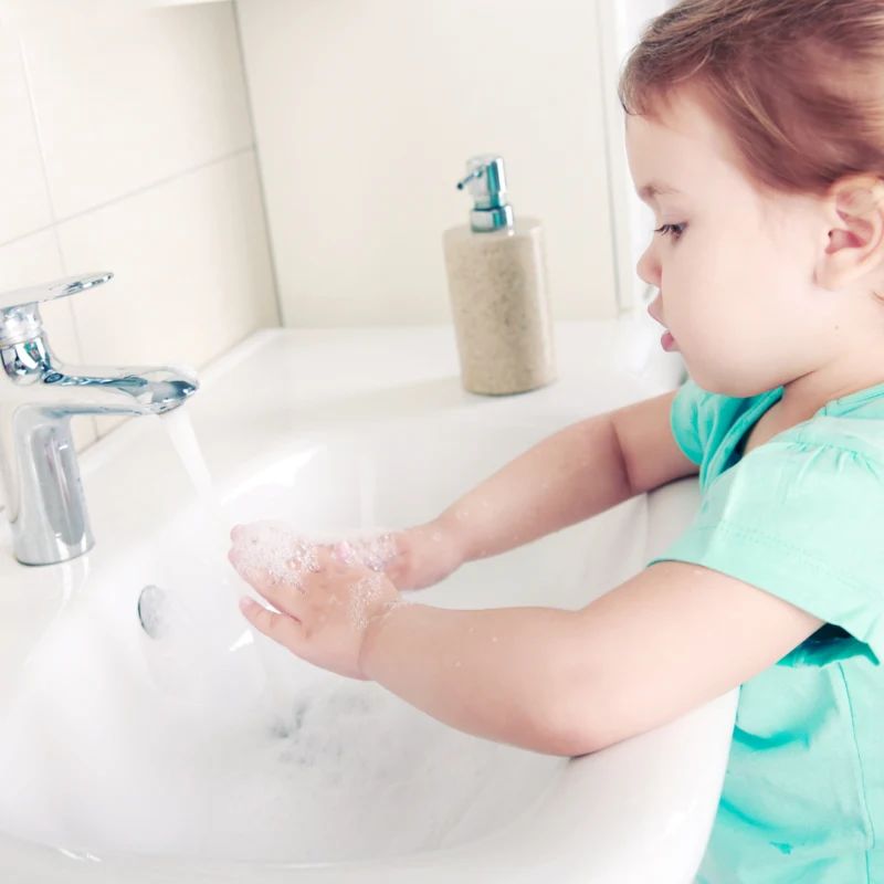 A young girl washing her hands