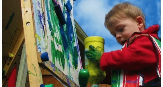 a boy painting at an easel