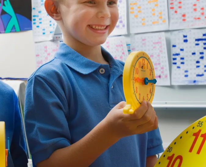A young boy learning to tell time with the Judy Clock