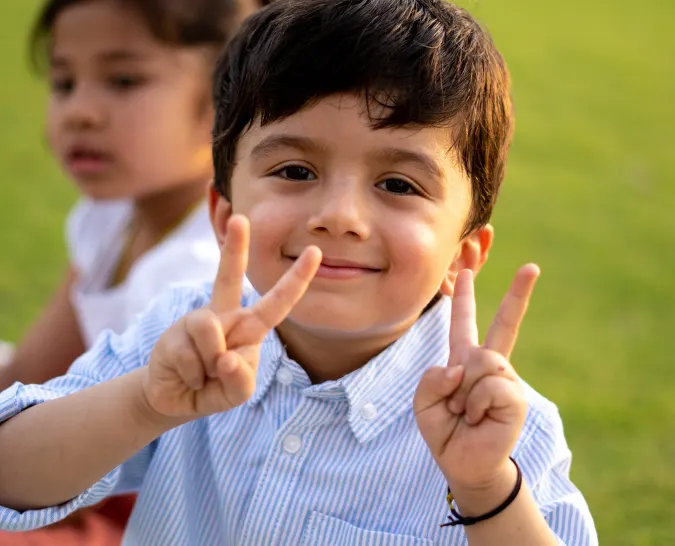 A young boy giving the peace sign
