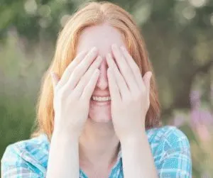 A woman putting her hands over her eyes