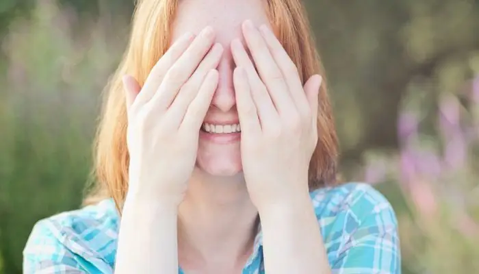 a woman placing her fingers over her eyes