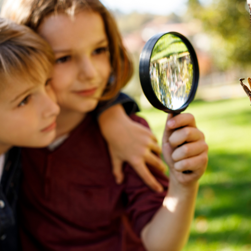 kids with a magnifying glass outside
