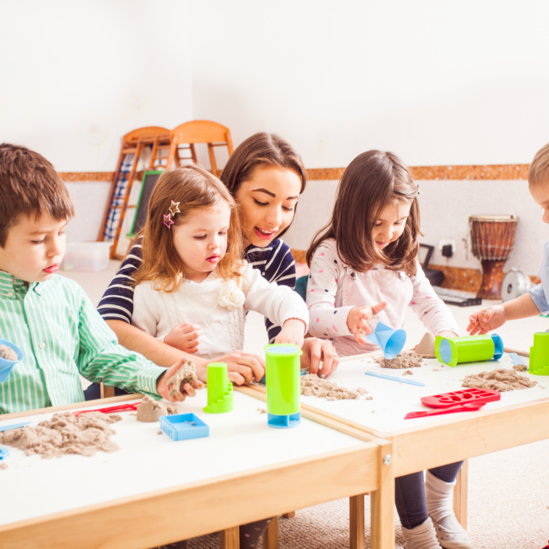 A group of kids playing with kinetic sand indoors