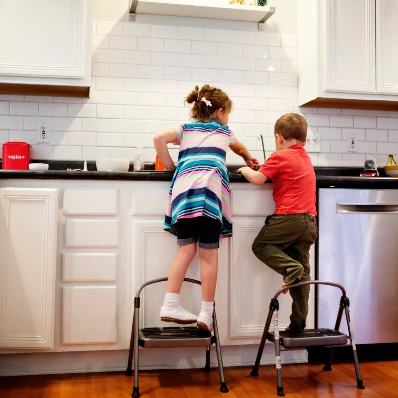 A young girl and boy cleaning a kitchen
