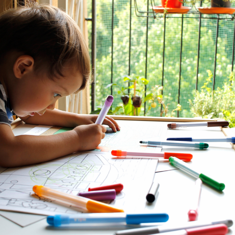 a young boy coloring at a table