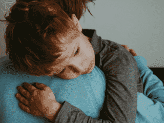 anxious child getting hug from mother