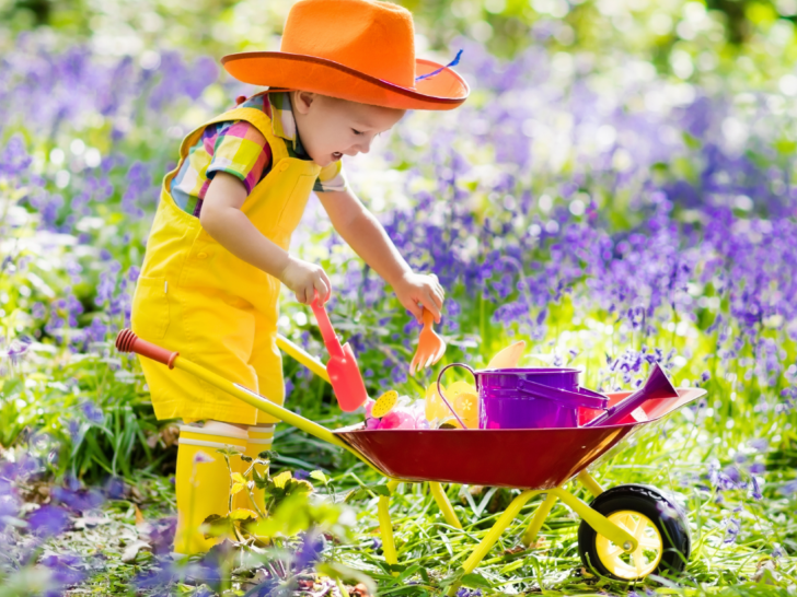 a young child gardening with a wheelbarrow