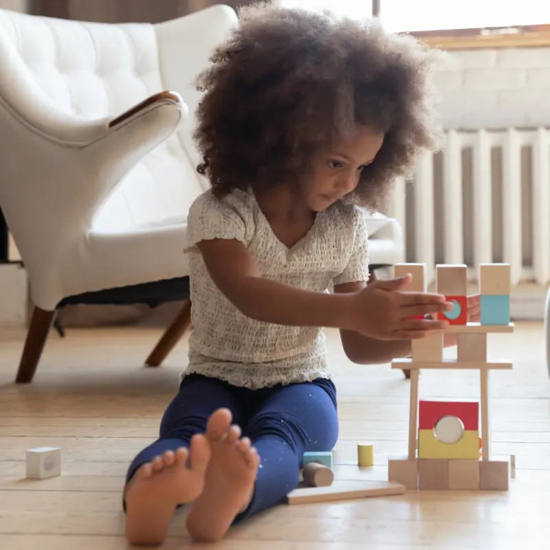 a young girl building with blocks