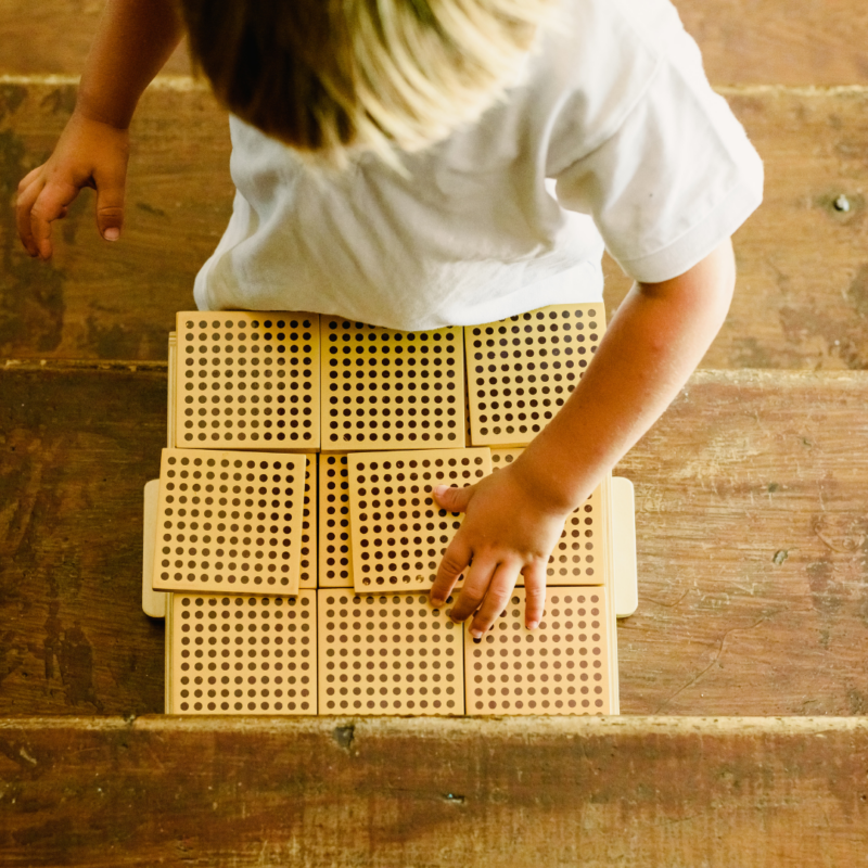 A child working with Montessori thousand cubes
