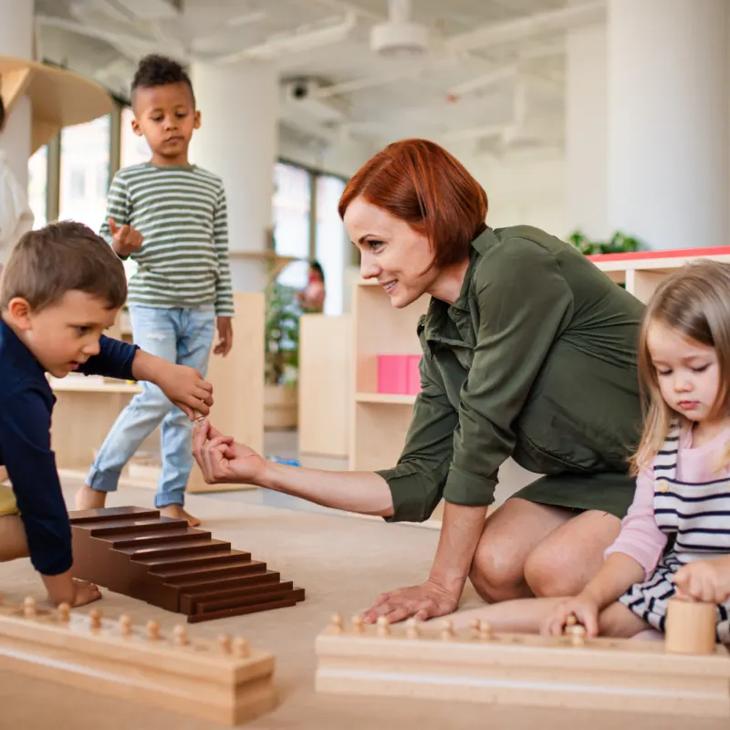 a Montessori guide working with sensorial in the classroom with children