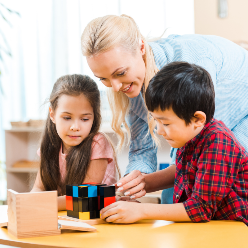a Montessori guide working with the binomial cube in the classroom with children