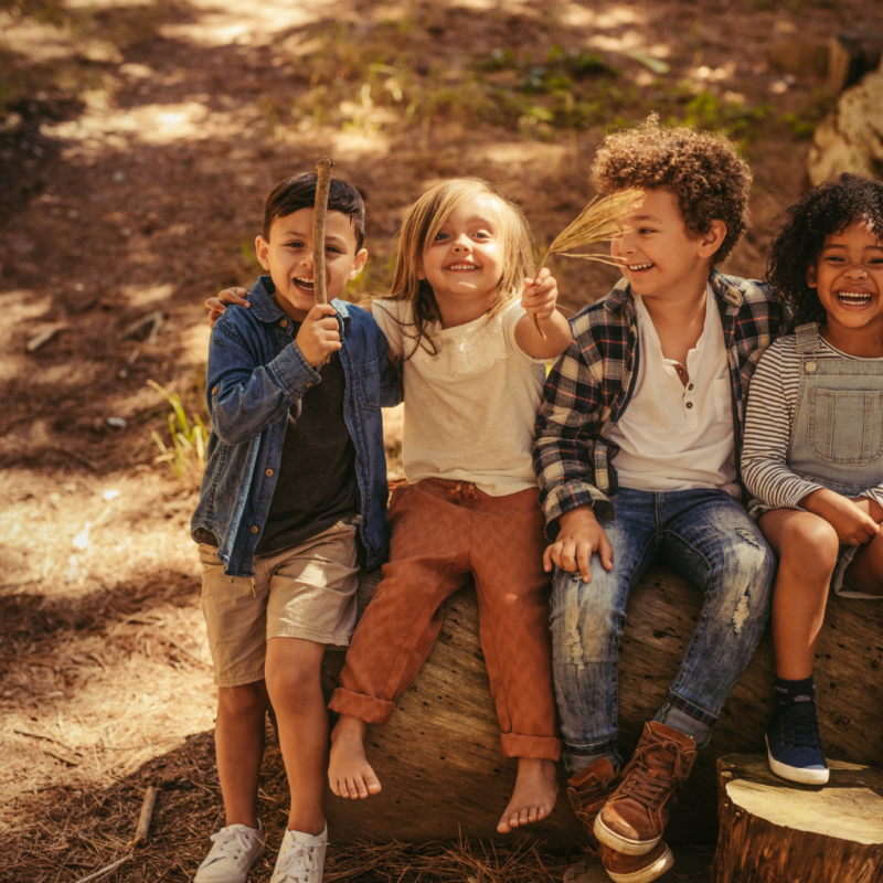 happy children sitting on a log