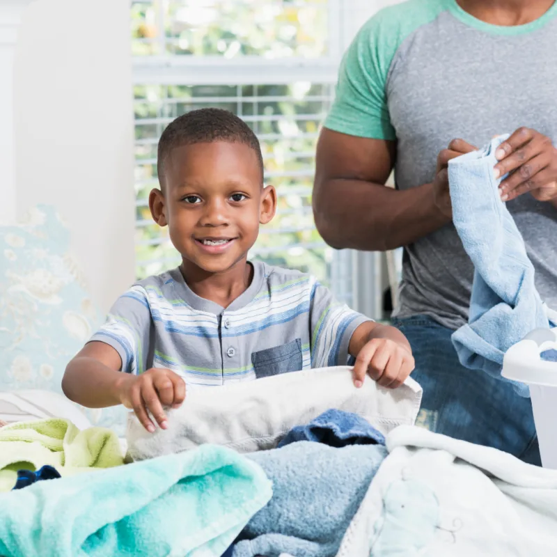A young boy folding laundry