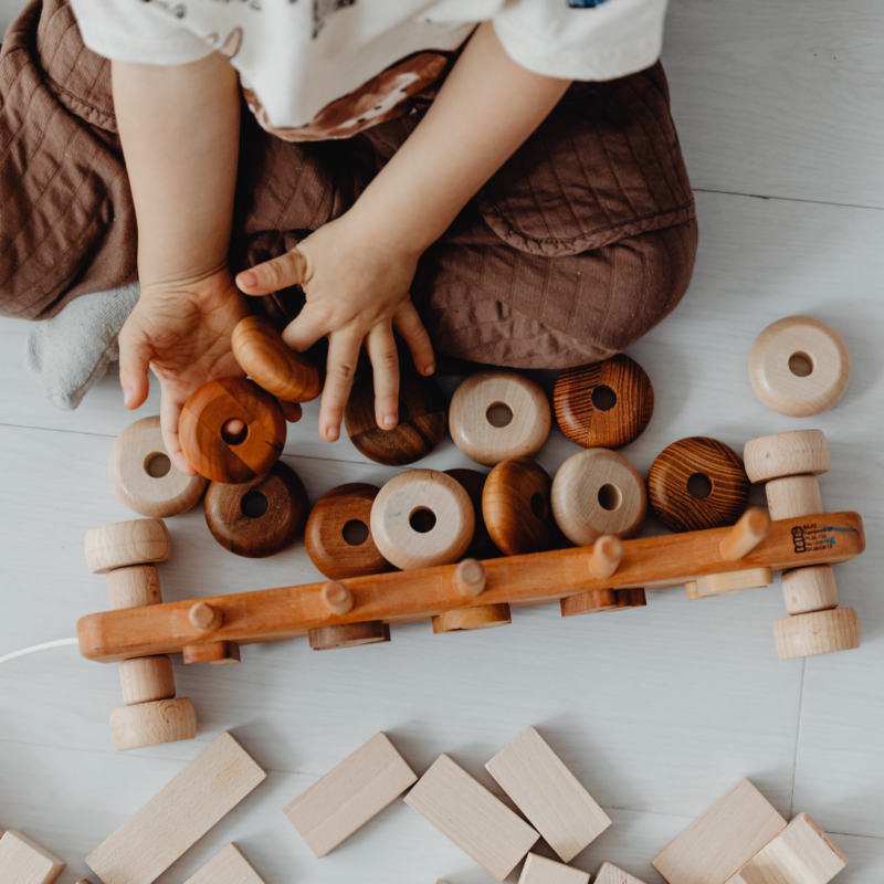 a young child playing with a wooden toy