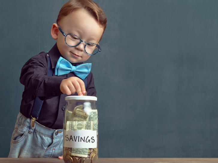 cute-child-putting-money-into-a-savings-jar
