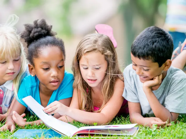 three kids reading outside