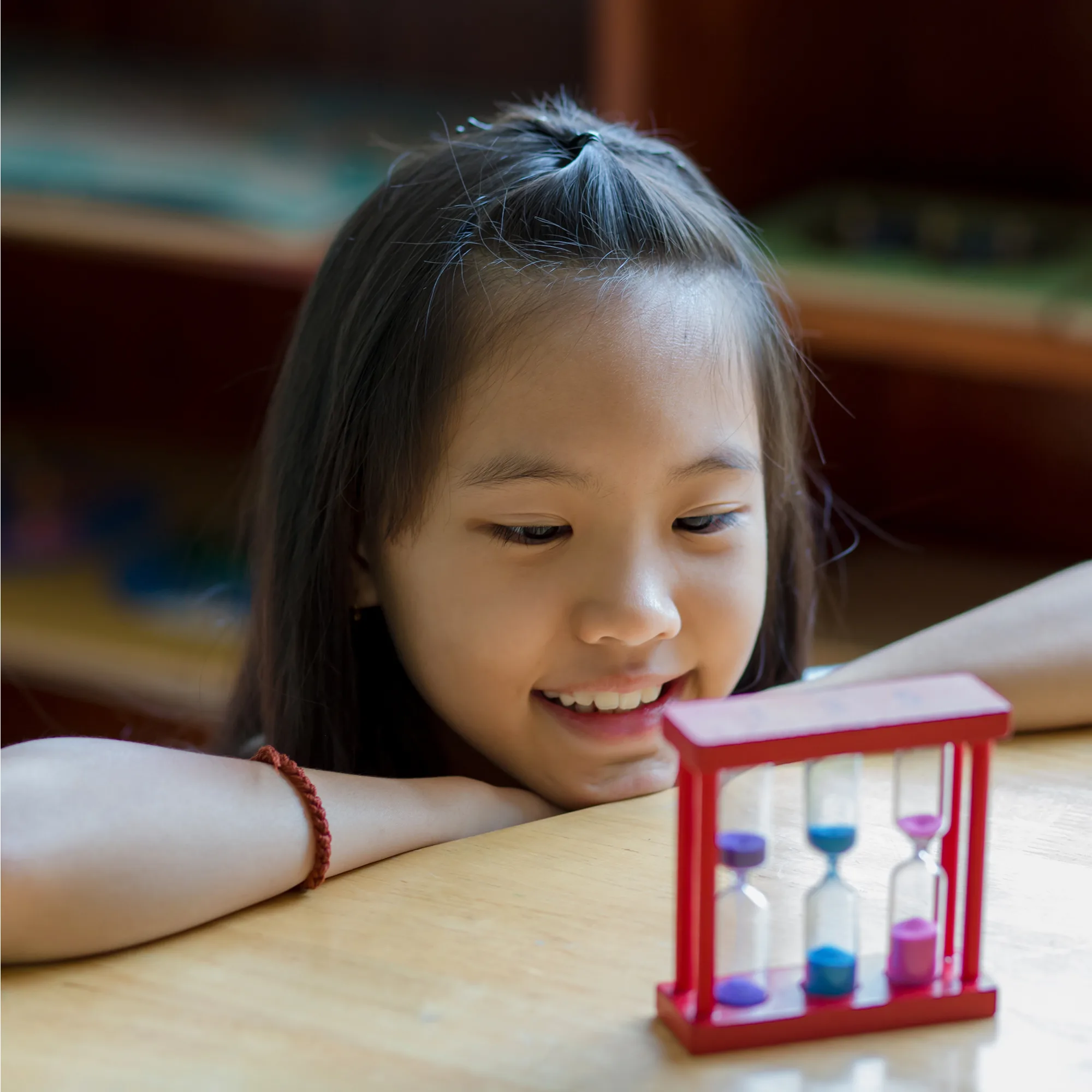 a young girl watching sand timers