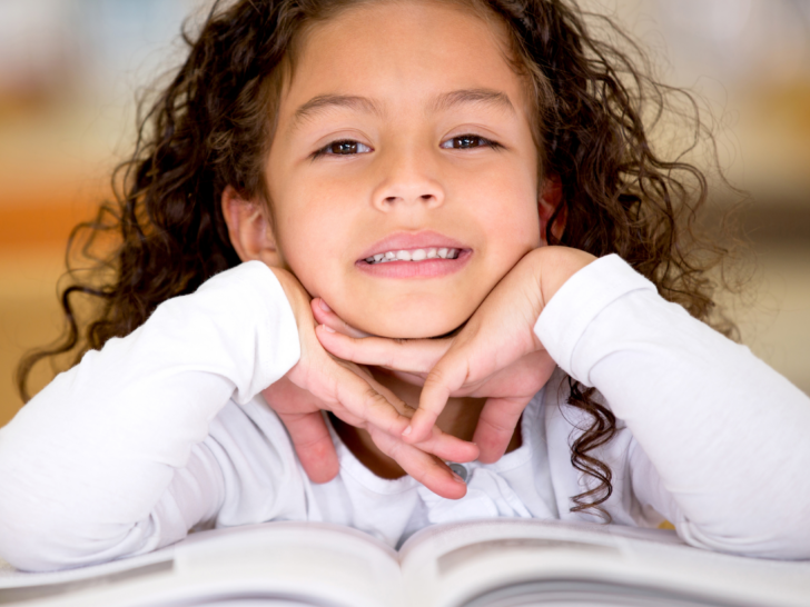 a-close-up-of-a-young-girl-reading-an-open-faced-book